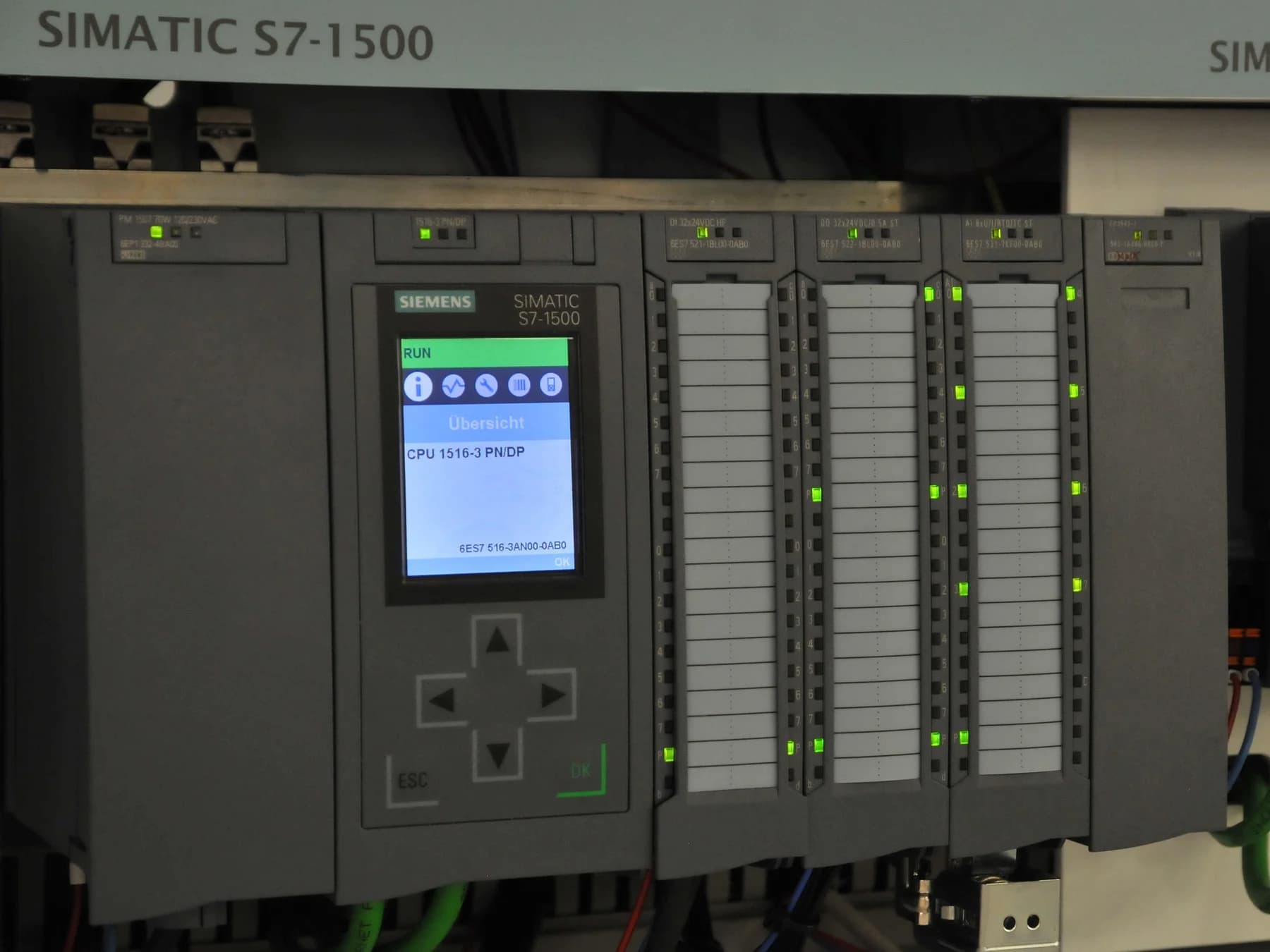 Eine Siemens SIMATIC S7-1500-Steuerung mit Display und einer Reihe von Ein- und Ausgabemodulen.